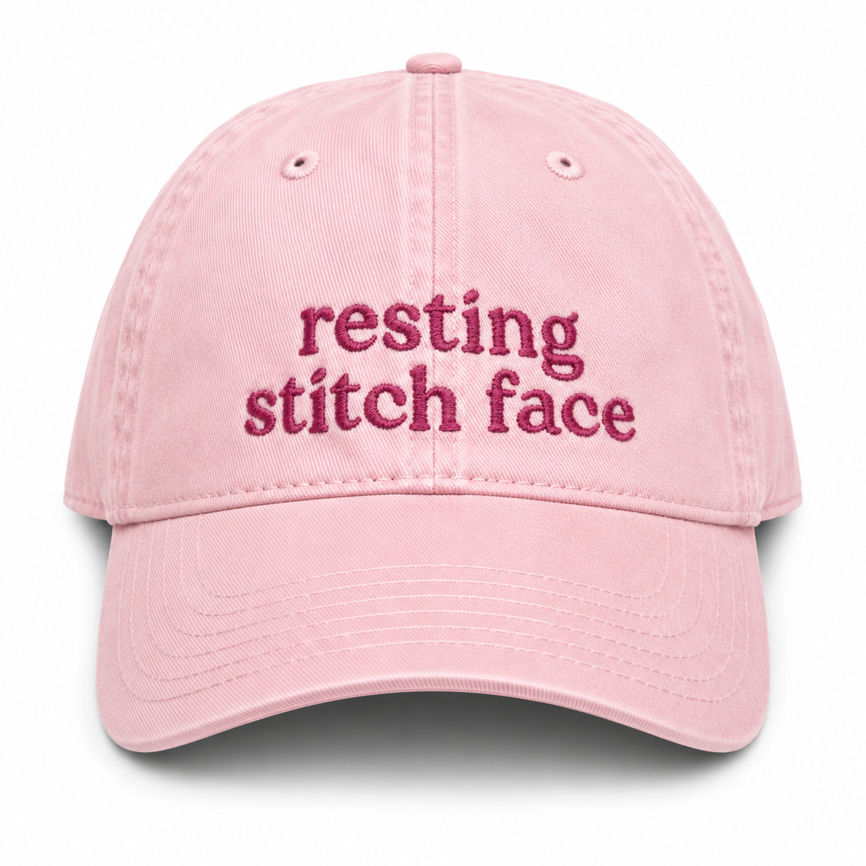 Pink cap with 'resting stitch face' text on a white background