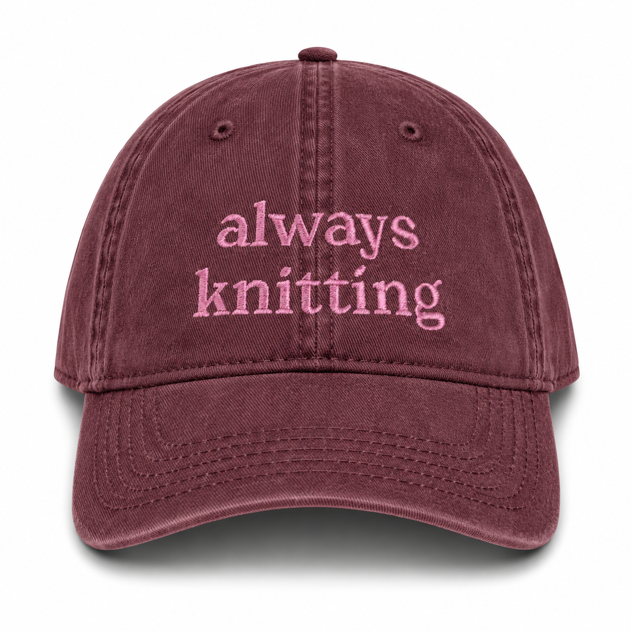 Maroon cap with 'always knitting' text on a white background