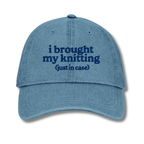Blue cap with text 'i brought my knitting (just in case)' on a white background