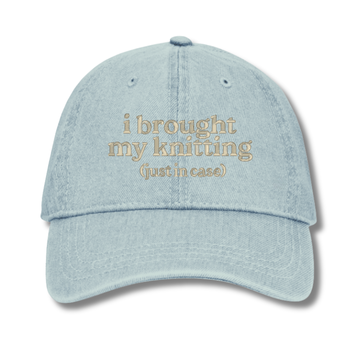 Light blue cap with text 'i brought my knitting (just in case)' on a white background