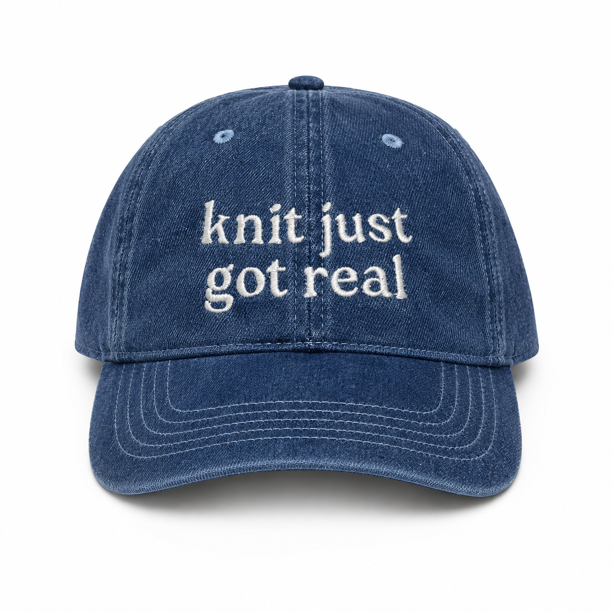 Blue denim cap with 'knit just got real' text on a white background