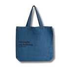 Blue denim tote bag with text on a white background