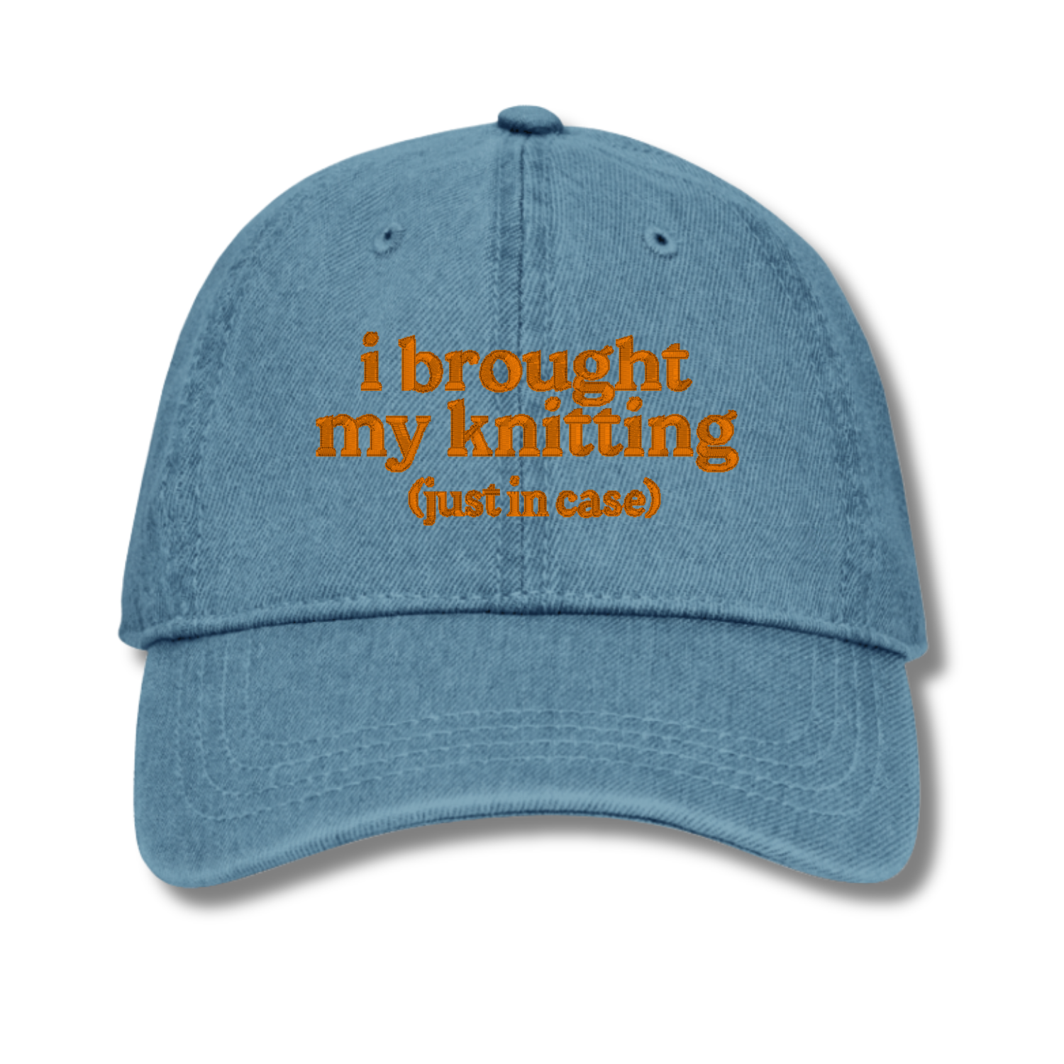 Blue cap with orange text 'i brought my knitting (just in case)' on a white background