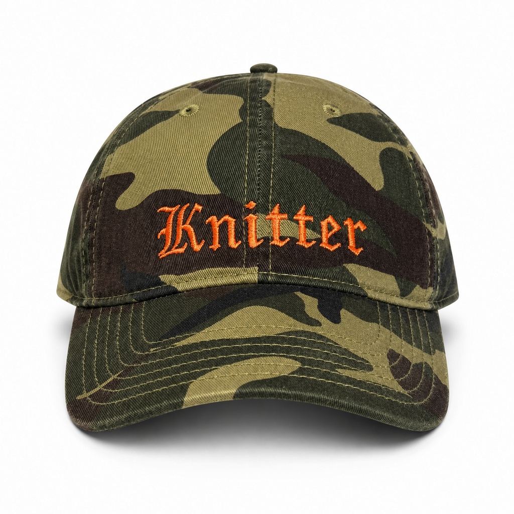 Camouflage baseball cap with 'Knitter' embroidery on a white background