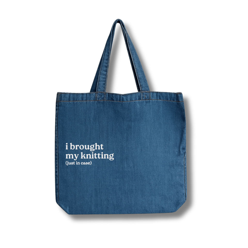 Blue tote bag with text 'i brought my knitting (just in case)' on a white background