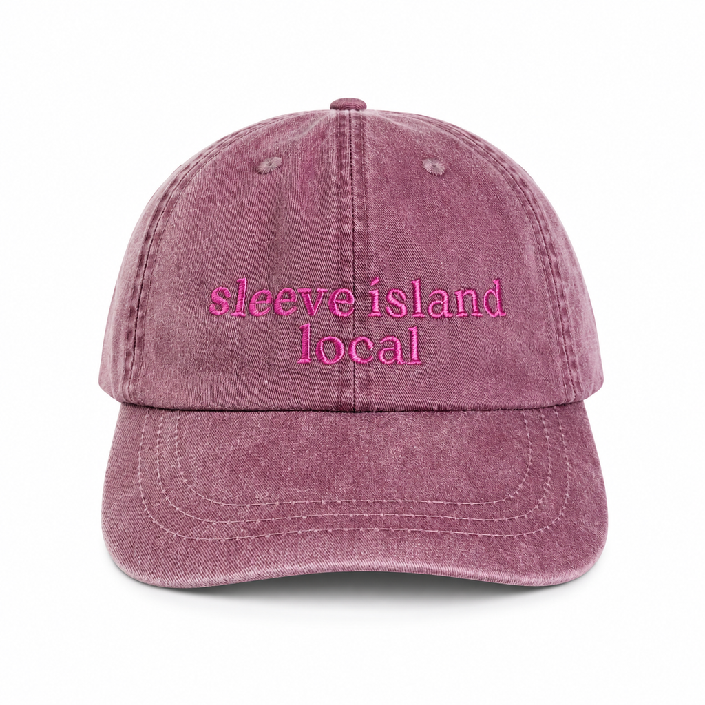Pink denim cap with 'sleeve island local' text on a white background