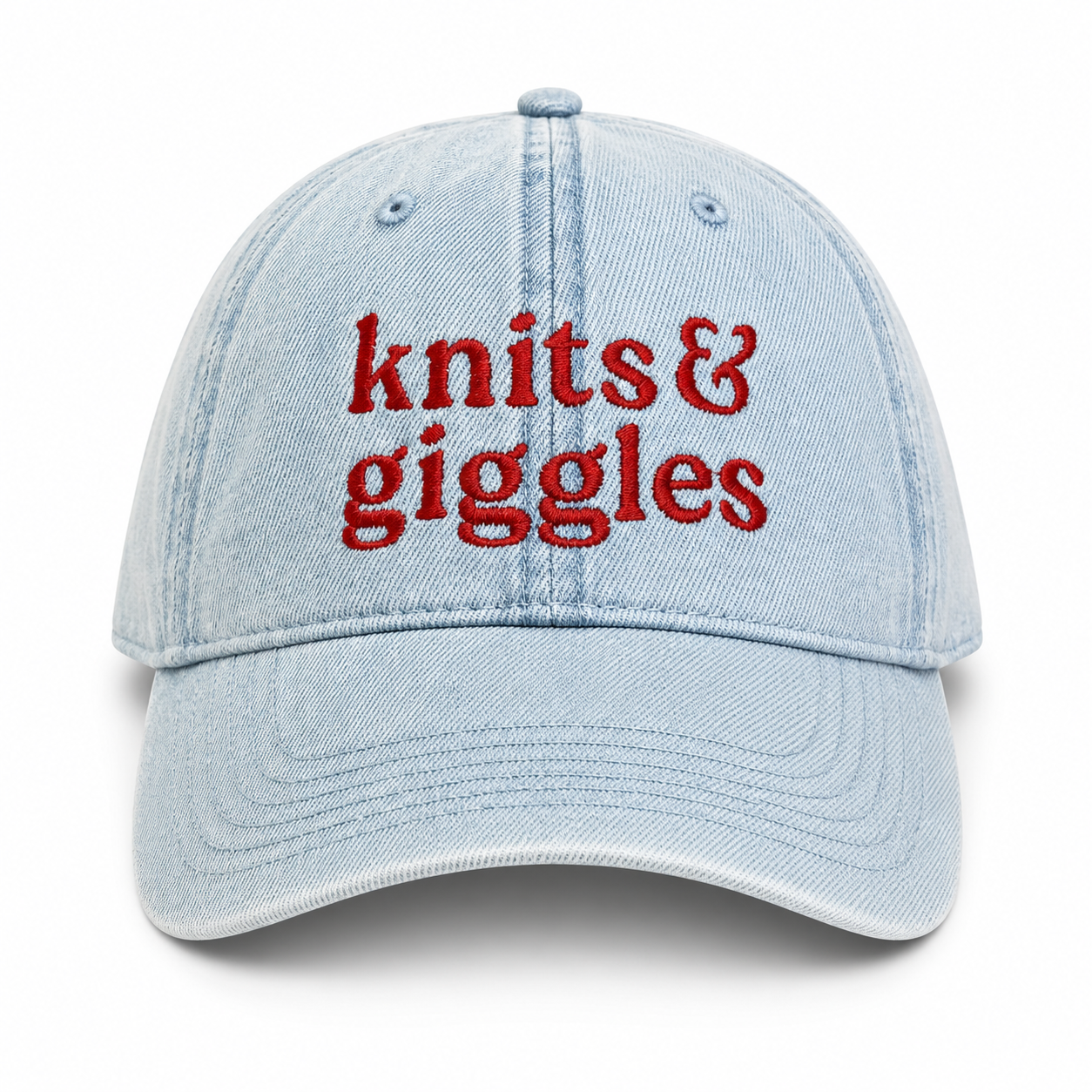 Light blue cap with 'knits & giggles' text in red on a white background