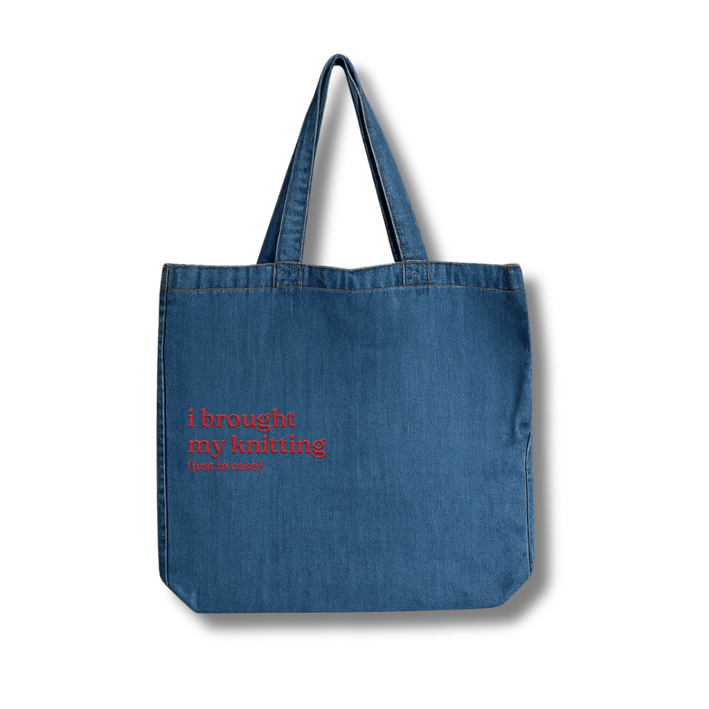 Blue denim tote bag with red text on a white background