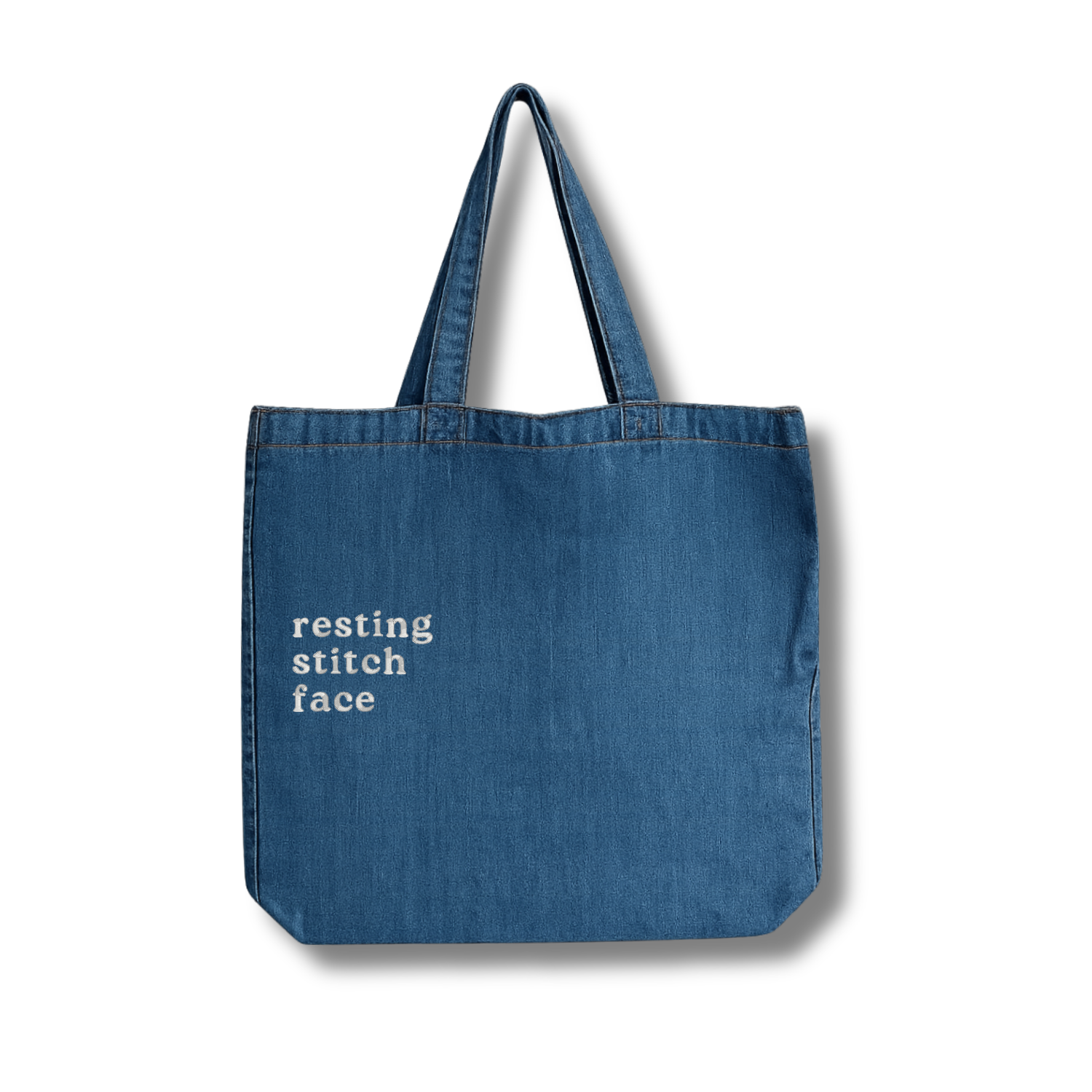 Blue tote bag with 'resting stitch face' text on a white background