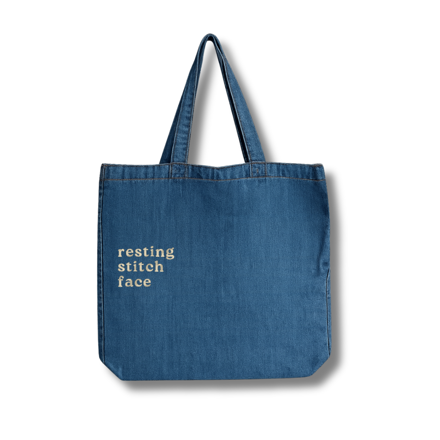 Blue tote bag with 'resting stitch face' text on a white background