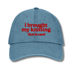 Blue cap with red text 'i brought my knitting (just in case)' on a white background