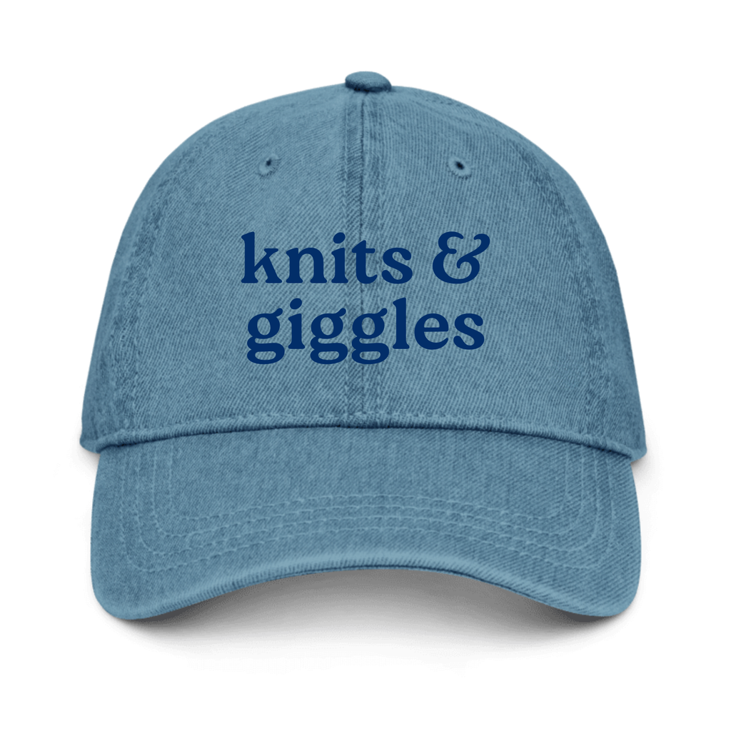 Blue denim cap with 'knits & giggles' text on a white background