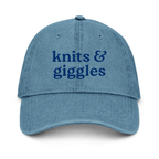 Blue denim cap with 'knits & giggles' text on a white background