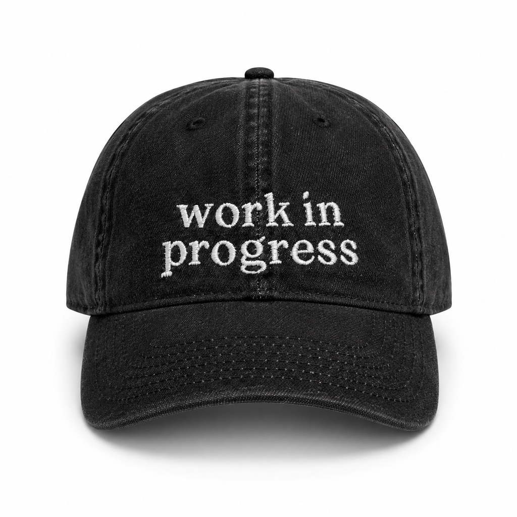 Black cap with 'work in progress' text on a white background