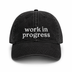 Black cap with 'work in progress' text on a white background