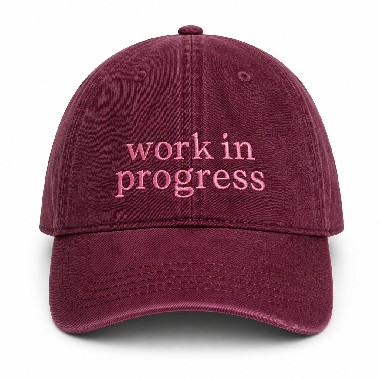 Maroon cap with 'work in progress' text on a white background