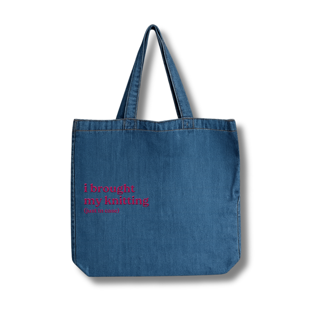 Blue denim tote bag with pink text on a white background
