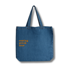 Blue denim tote bag with 'resting stitch face' text on a white background