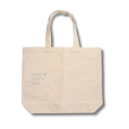 Beige tote bag with 'nesting stitch face' text on a white background