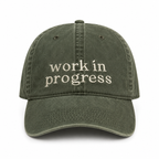Green cap with 'work in progress' text on a white background