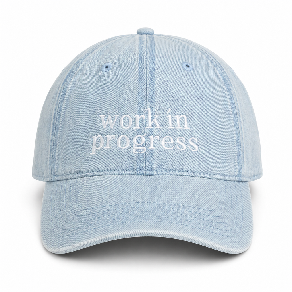 Light blue cap with 'work in progress' text on a white background