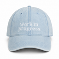 Light blue cap with 'work in progress' text on a white background