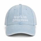 Light blue cap with 'work in progress' text on a white background
