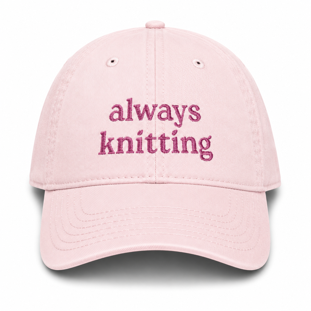 Pink cap with 'always knitting' text on a white background