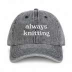 Gray cap with 'always knitting' text on a white background
