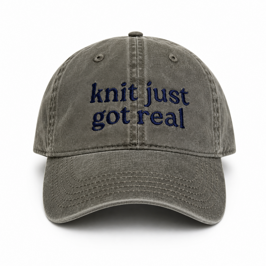 Gray cap with 'knit just got real' text on a white background