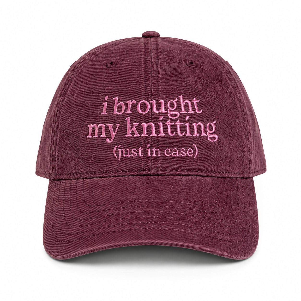Maroon cap with pink text 'i brought my knitting (just in case)' on a white background