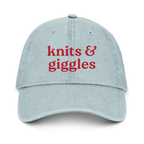 Light blue cap with 'knits & giggles' text in red on a white background