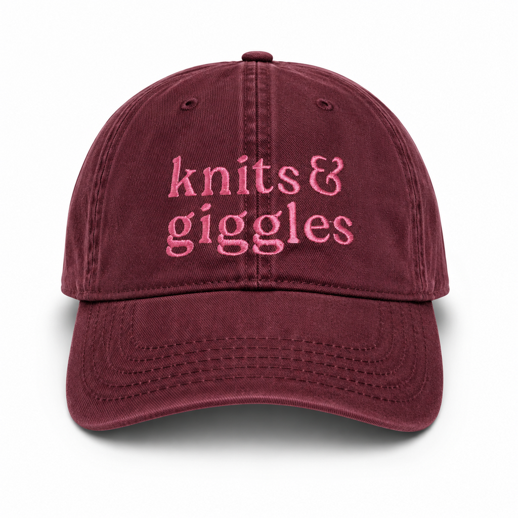 Maroon cap with 'knits & giggles' text in pink on a white background