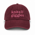 Maroon cap with 'knits & giggles' text in pink on a white background