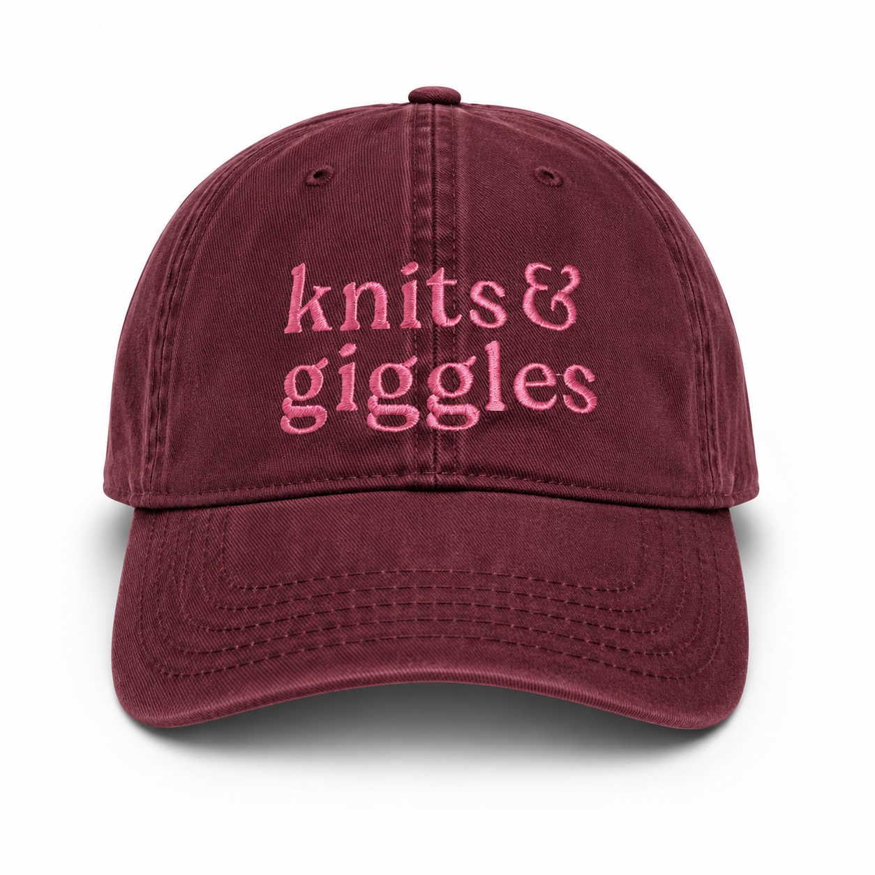 Maroon cap with 'knits & giggles' text in pink on a white background
