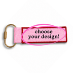 Pink keychain with gold carabiner and text 'choose your design!' on a white background