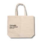 Beige tote bag with text 'i brought my crochet (just in case)' on a white background