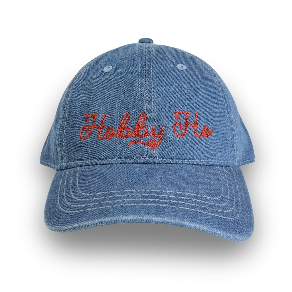 Blue denim cap with red embroidered text on a white background