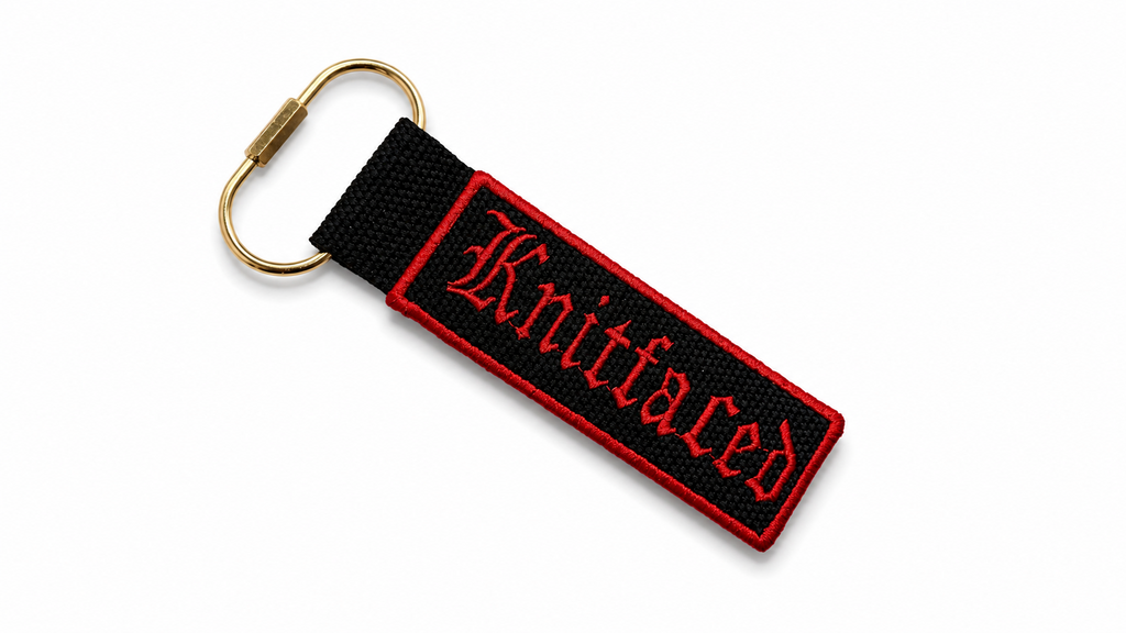 Black keychain with red text on a white background