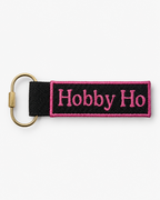 Keychain with 'Hobby Ho' text on a black strap against a white background