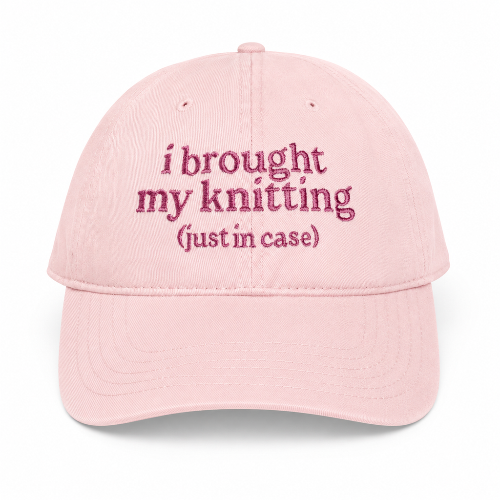 Pink cap with embroidered text on a white background