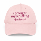 Pink cap with embroidered text on a white background