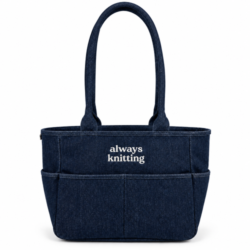 A navy blue denim-style tote bag with two top handles and the words 'always knitting' printed in white on the front, shown on a clean white background.