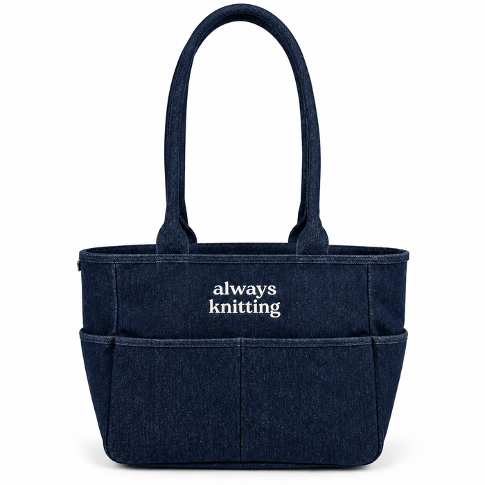 A navy blue denim-style tote bag with two top handles and the words 'always knitting' printed in white on the front, shown on a clean white background.