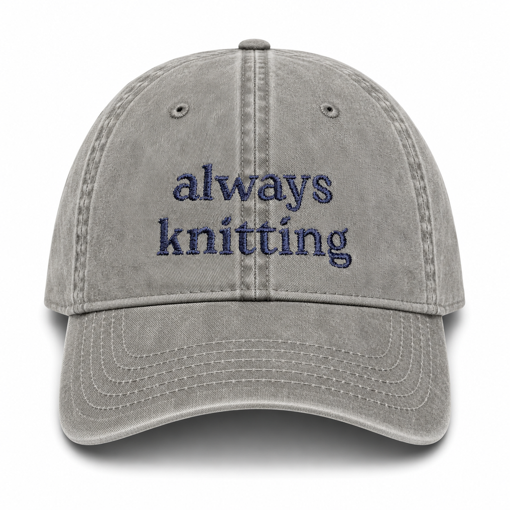 Gray cap with 'always knitting' text on a white background