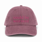 Mauve cap with 'could be worsted' text on a white background