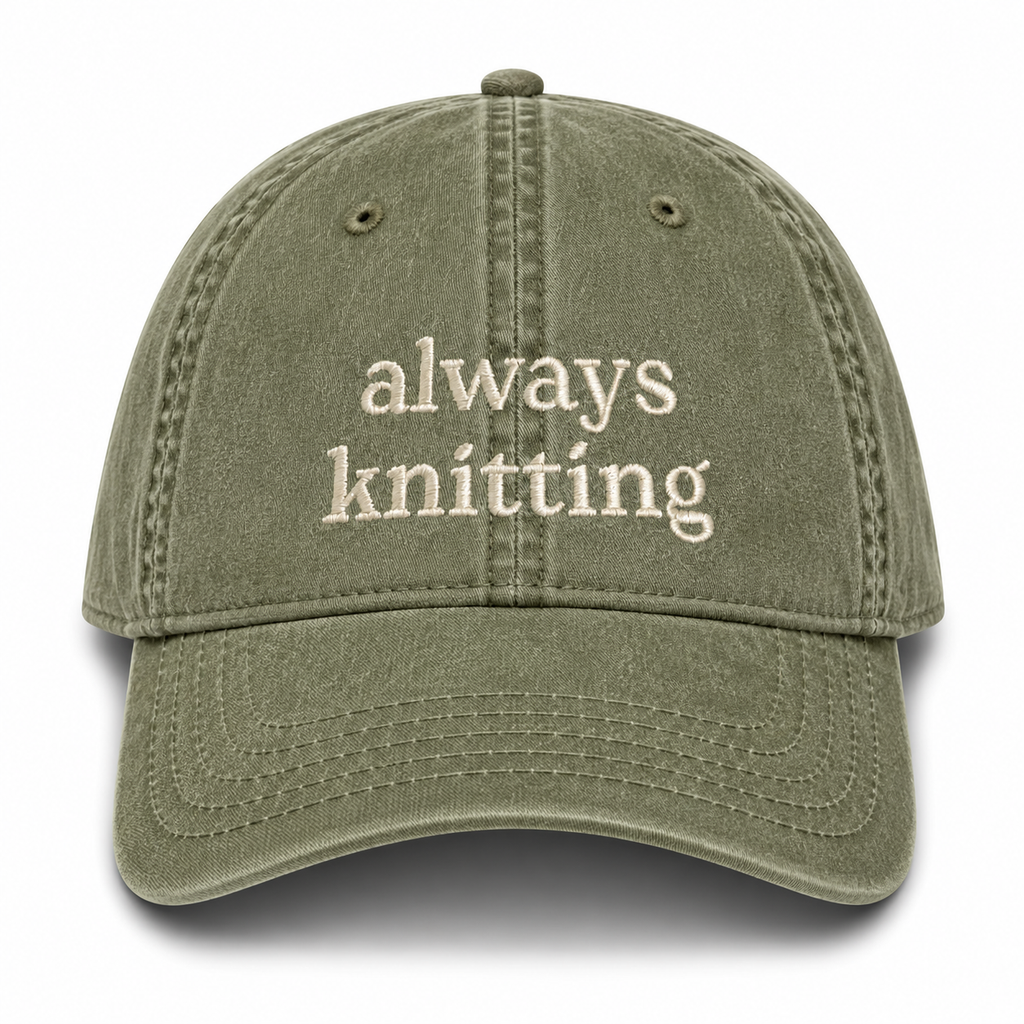 Green cap with 'always knitting' text on a white background