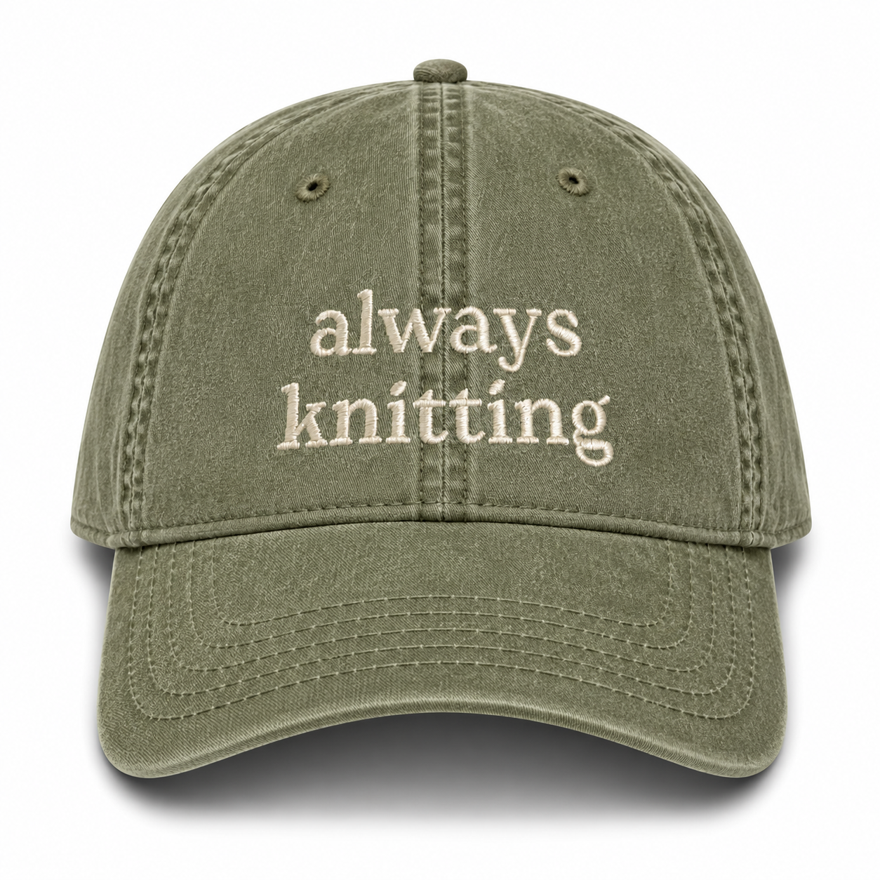 Green cap with 'always knitting' text on a white background