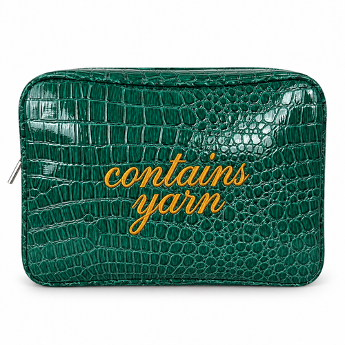 A green crocodile-embossed zippered pouch with the words 'contains yarn' written in gold cursive across the front, shown on a plain white background.