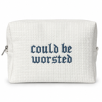 A white waffle-weave zippered pouch with the phrase 'could be worsted' embroidered in a dark blue Gothic font on the front, shown against a plain white background.